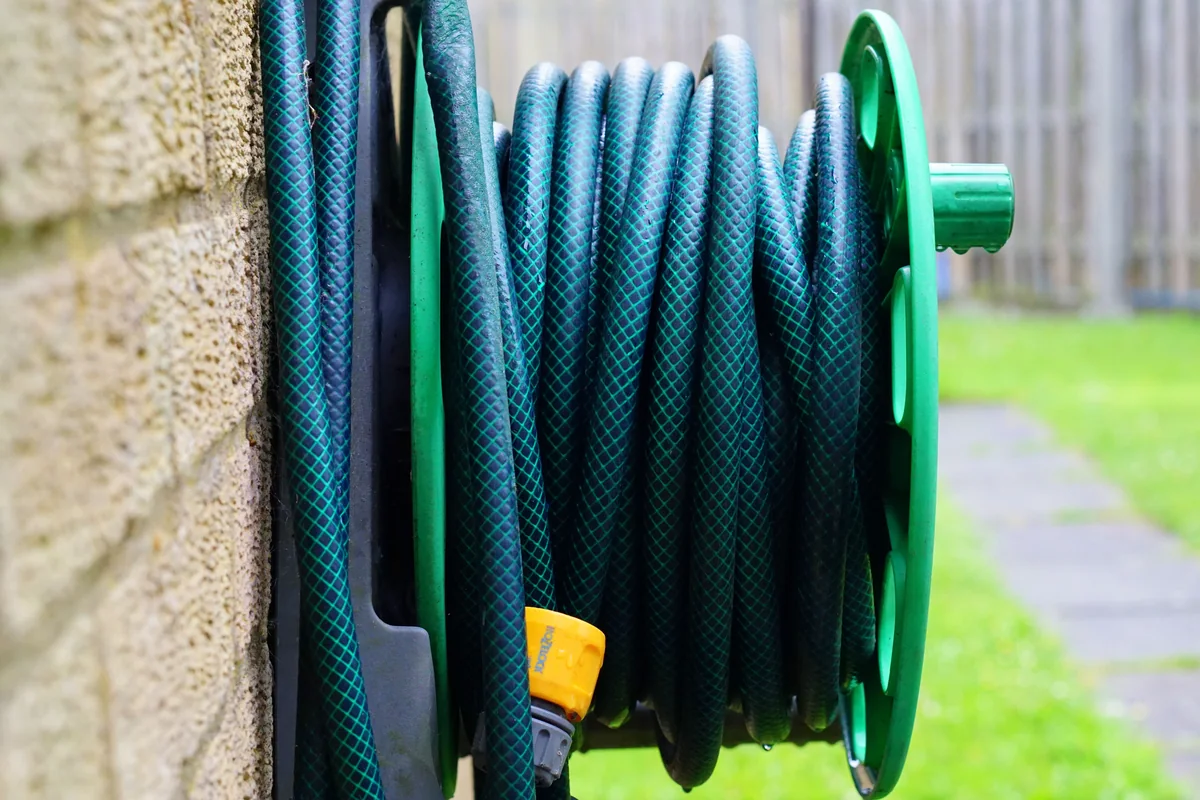 Coiled garden hose on a wall-mounted reel